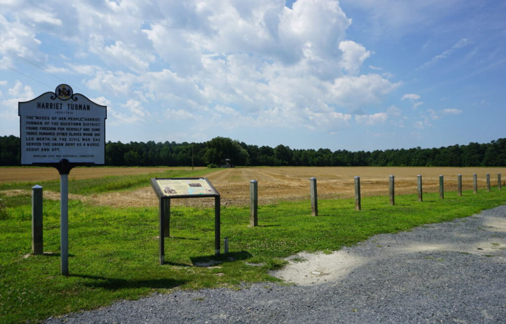 View of empty farmland and a sign noting a Harriet Tubman Underground Railroad site