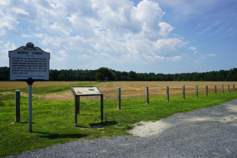 View of empty farmland and a sign noting a Harriet Tubman Underground Railroad site