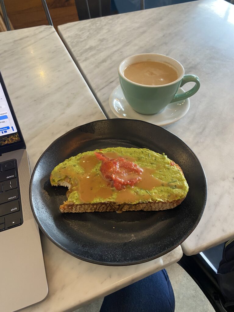 Plate of avocado toast and coffee mug on a cafe table