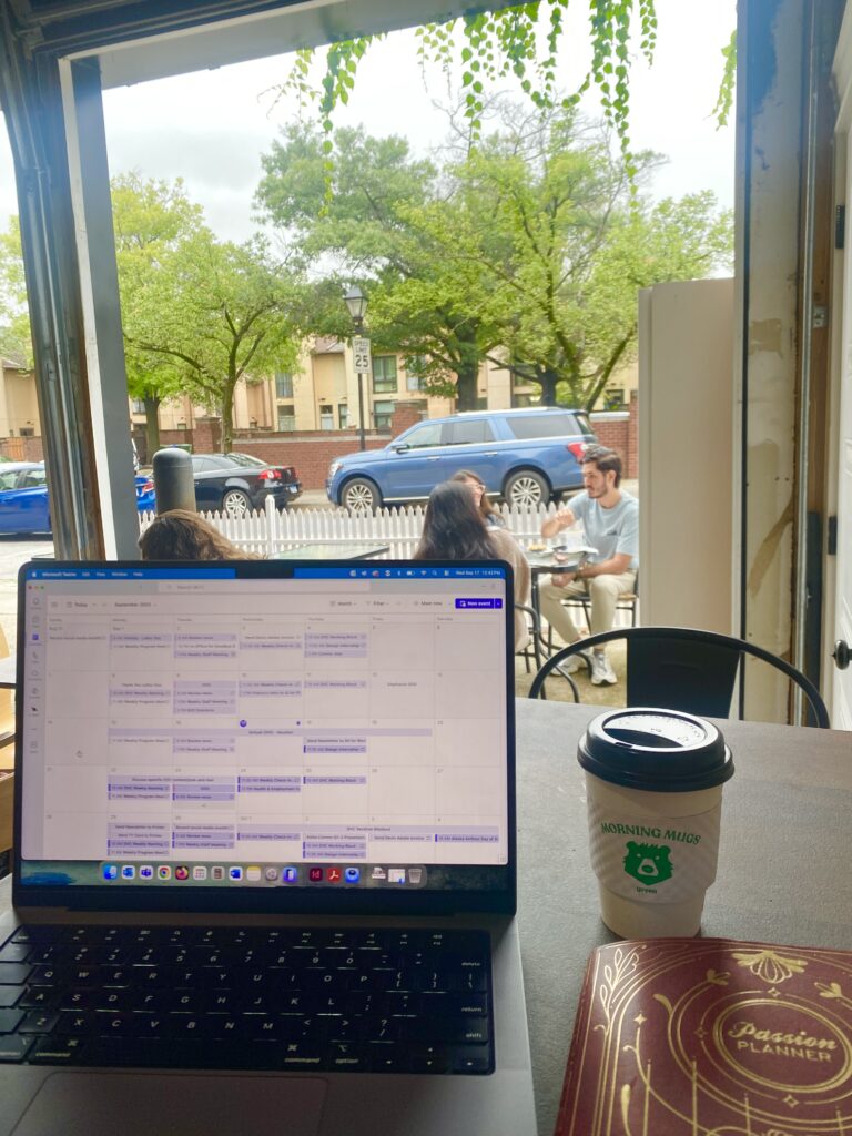 Inside of a Baltimore coffee shop with an open laptop and cup of coffee in foreground