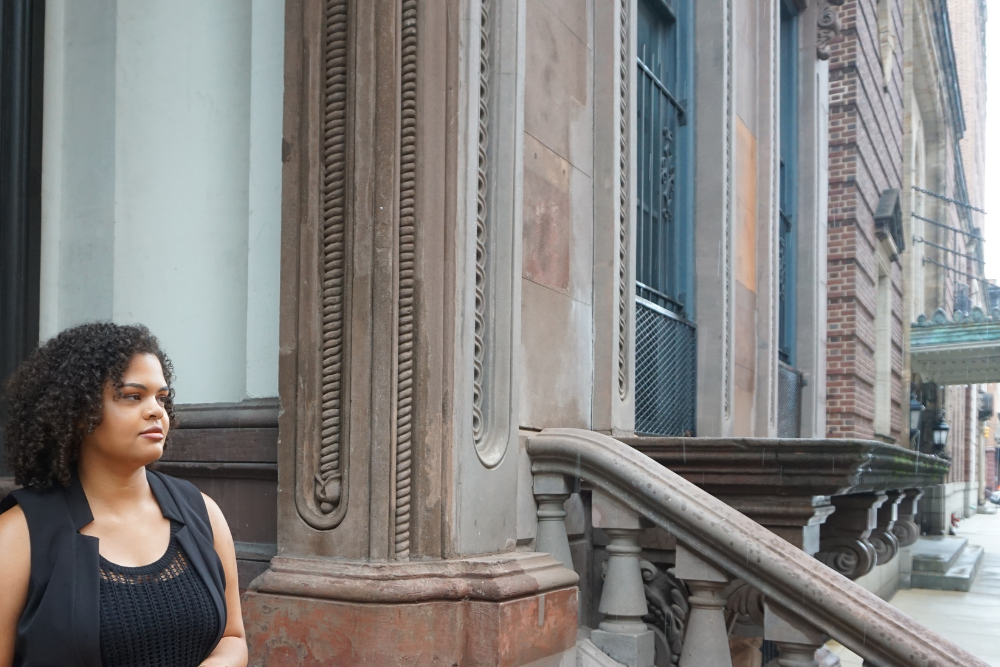 Woman sitting on a stoop on a Baltimore city street with historic architecture