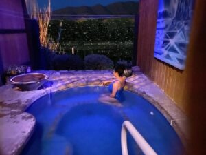 Woman lounging in a New Mexico hot spring pool at dusk