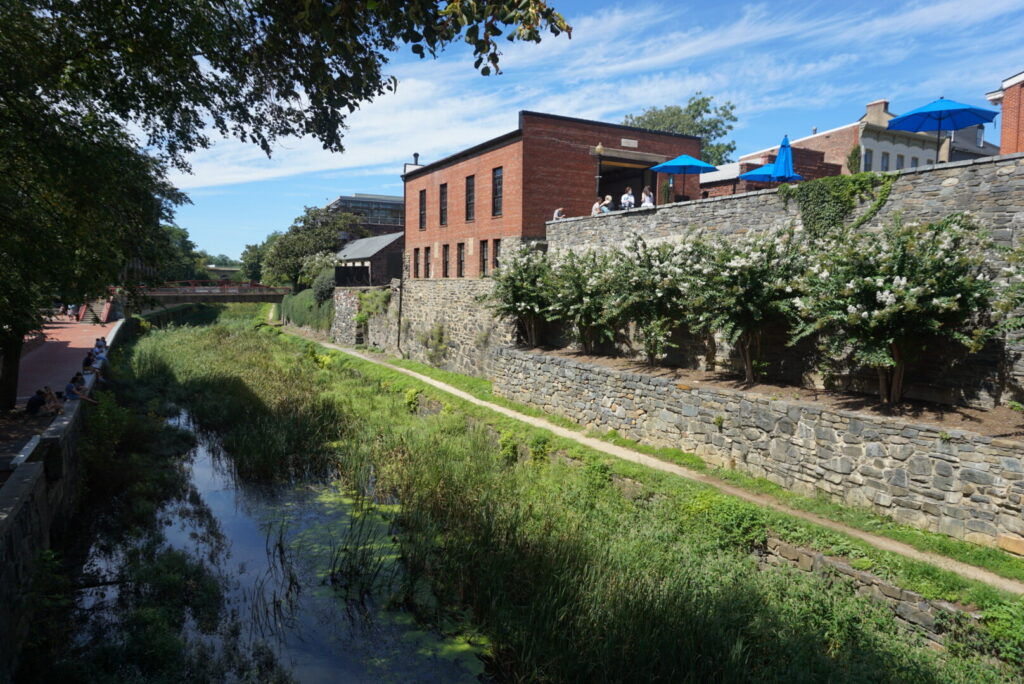 The C&O Canal with brick buildings and a stone wall alongside it