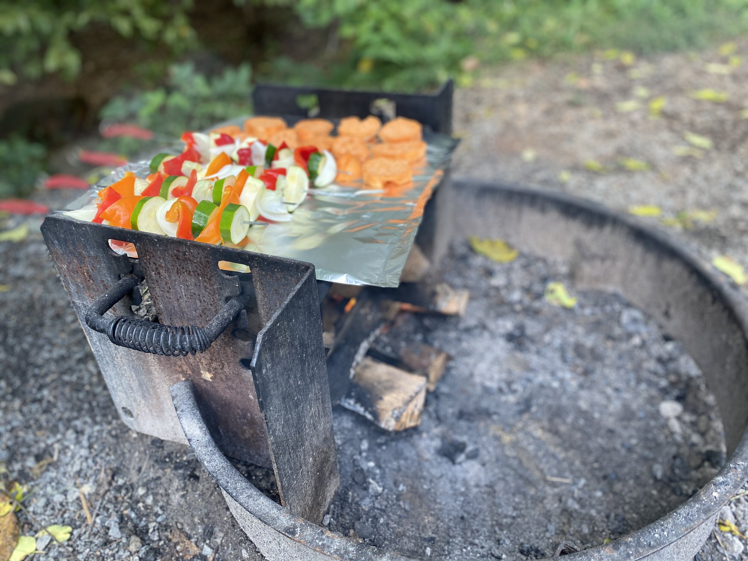Outdoor grill with vegetable skewers grilling