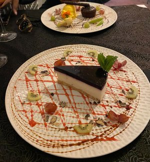 Slice of cheesecake on a plate decorated with garnish.