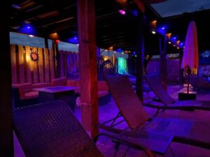 Lounge chairs and colorful lights at night within a New Mexico hot spring spa