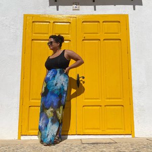 Woman standing in front of bright yellow double doors in Spain.