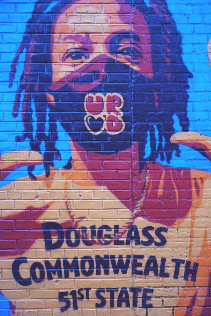Washington DC street mural showing a child with a t-shirt that says Douglass Commonwealth 51st State