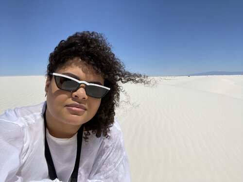 Selfie of woman in sunglasses with white gypsum sand dunes in the background in New Mexico