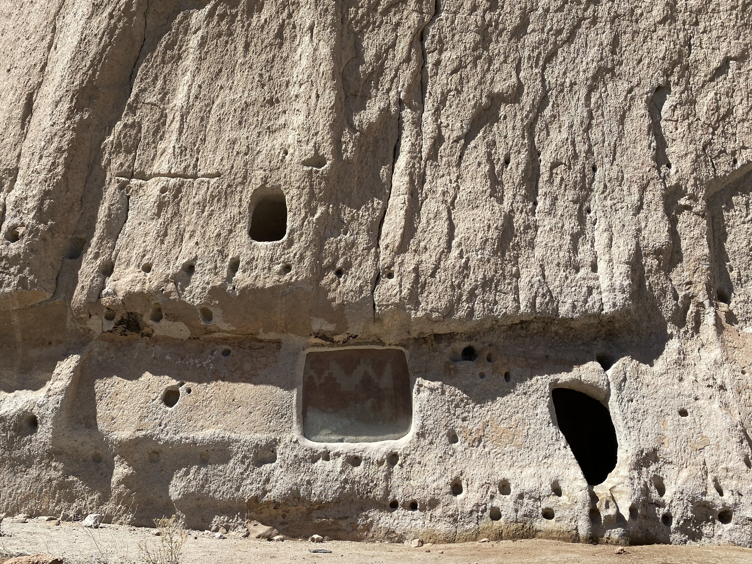 Ancient petroglyphs and original art on a cliff at Bandelier National Monument