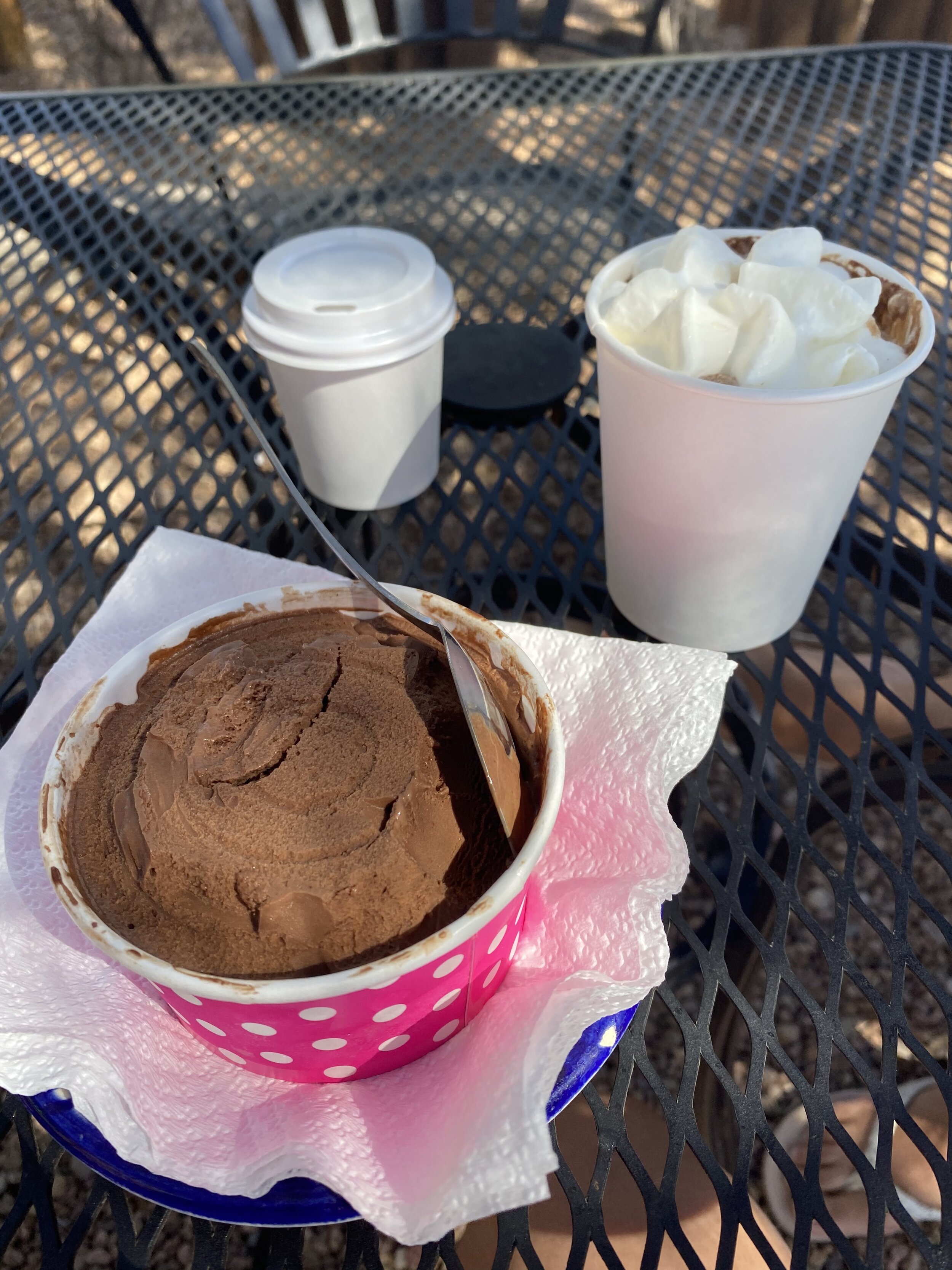 Small bowl of chocolate chili ice cream and cup of hot chocolate on a table