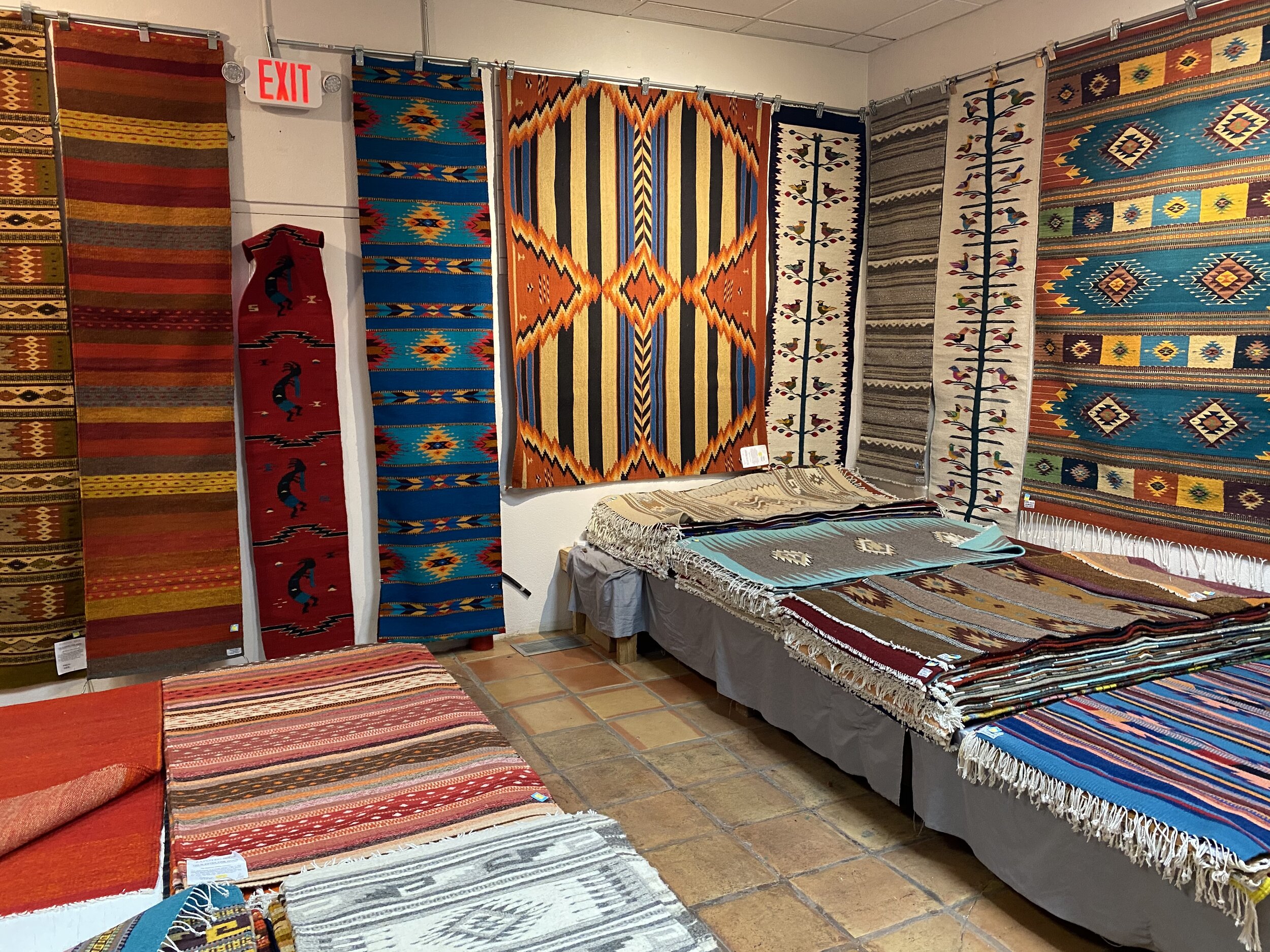 Rug store display of colorful, patterned Southwestern rugs