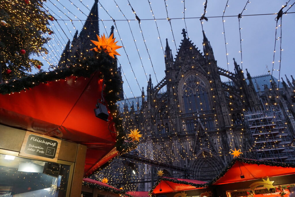A part of the Cologne Cathedral in Germany above the Christmas market booths and lights