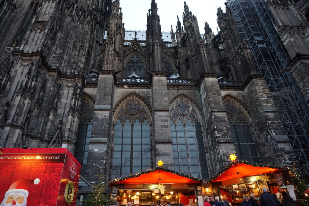 A part of the Cologne Cathedral in Germany above the Christmas market booths and lights