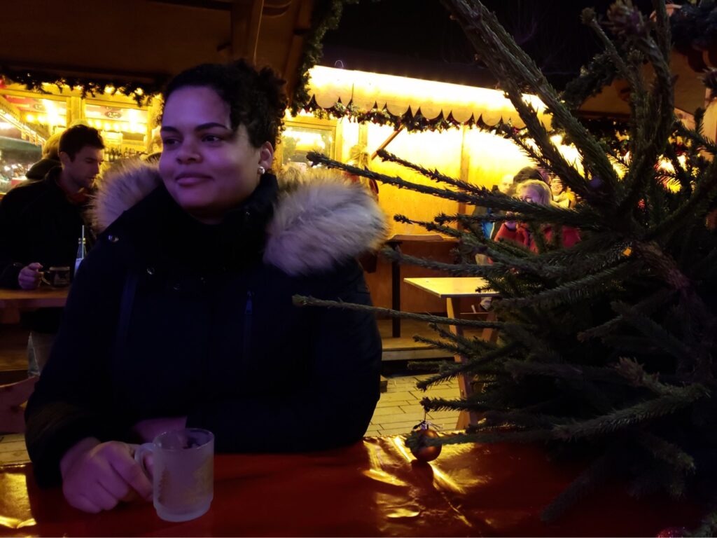 Woman with a mug at a standing table at a Christmas market in Dusseldorf, Germany