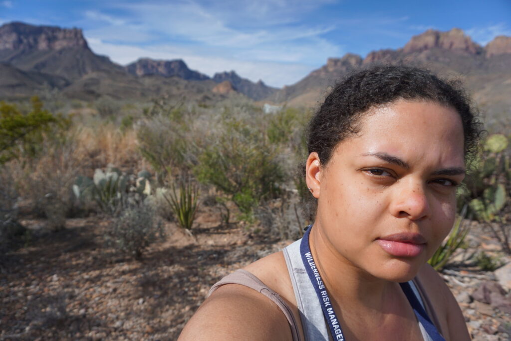 Woman in a selfie with mountains and Texas desert in the background