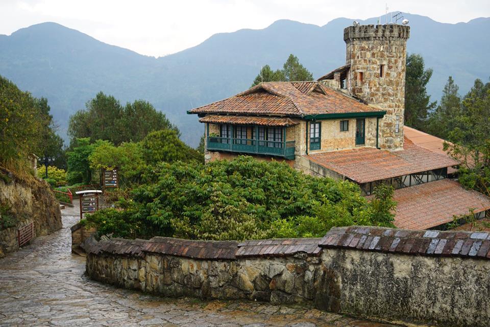 Historic building along a stone path with mountain range outline in the background
