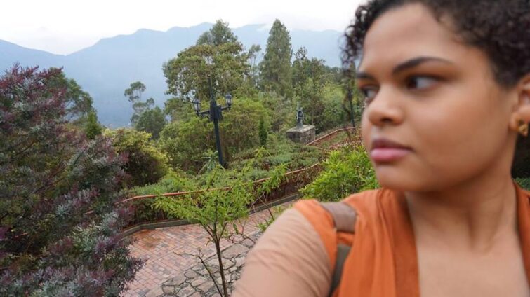 Selfie of woman with mountains and greenery in background