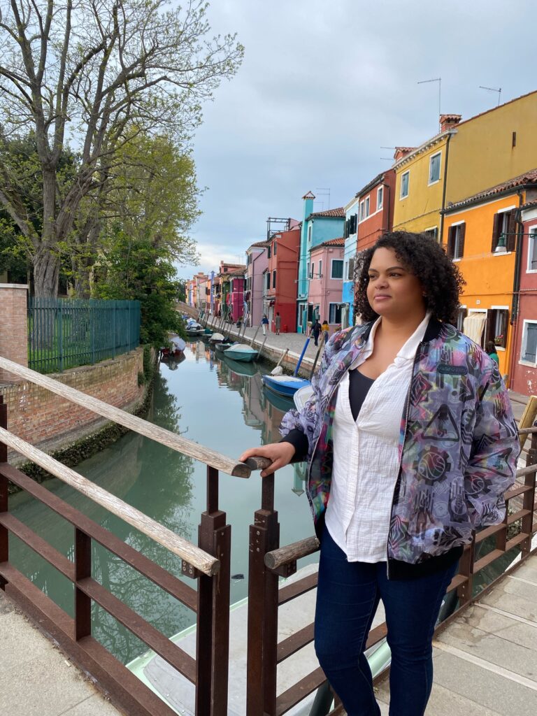 Woman standing on bridge over a canal on Burano Island in Venice Italy