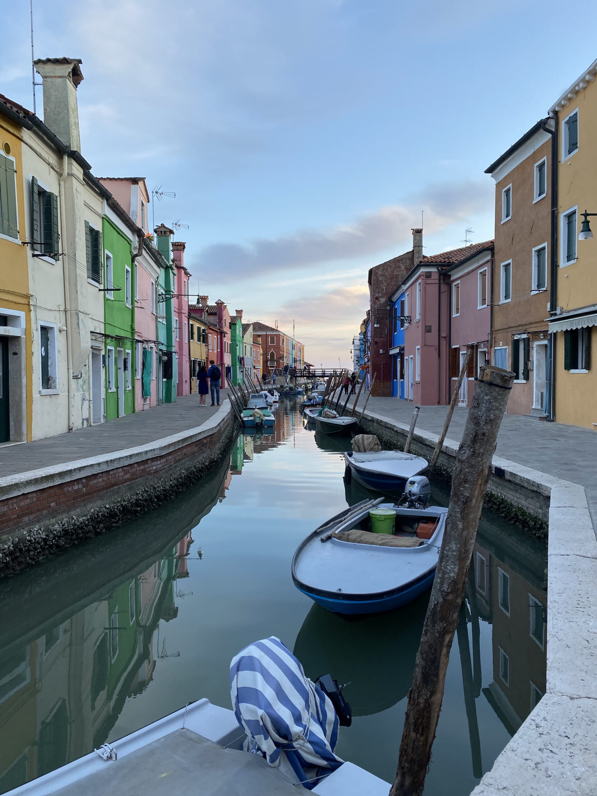 Canal lined by colorful rowhomes on Burano in Venice Italy