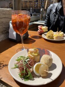 Plates of finger foods and Aperol Spritz drinks on a table in Venice Italy