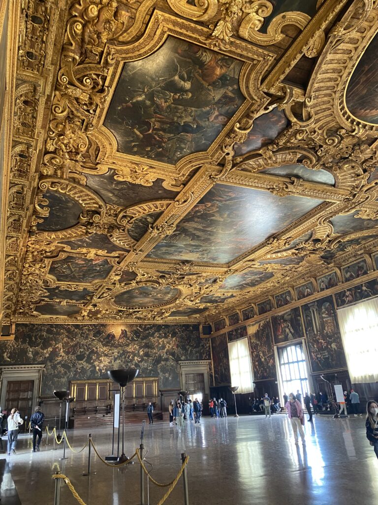 Large ballroom with ornate gold and painted ceiling in Venice Italy