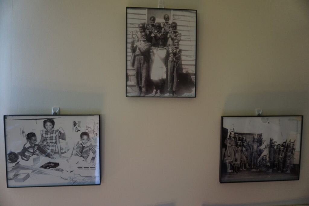 Three black and white pictures of former black schoolhouse students on the wall