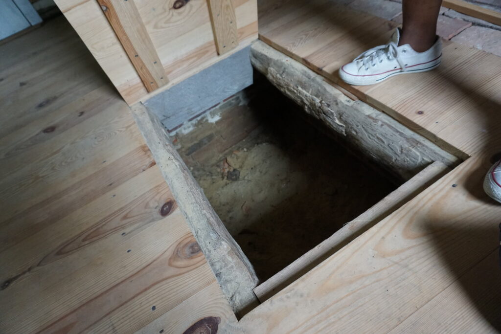 A door in a historic cabin floor leading to an underground hiding place for escaped slaves