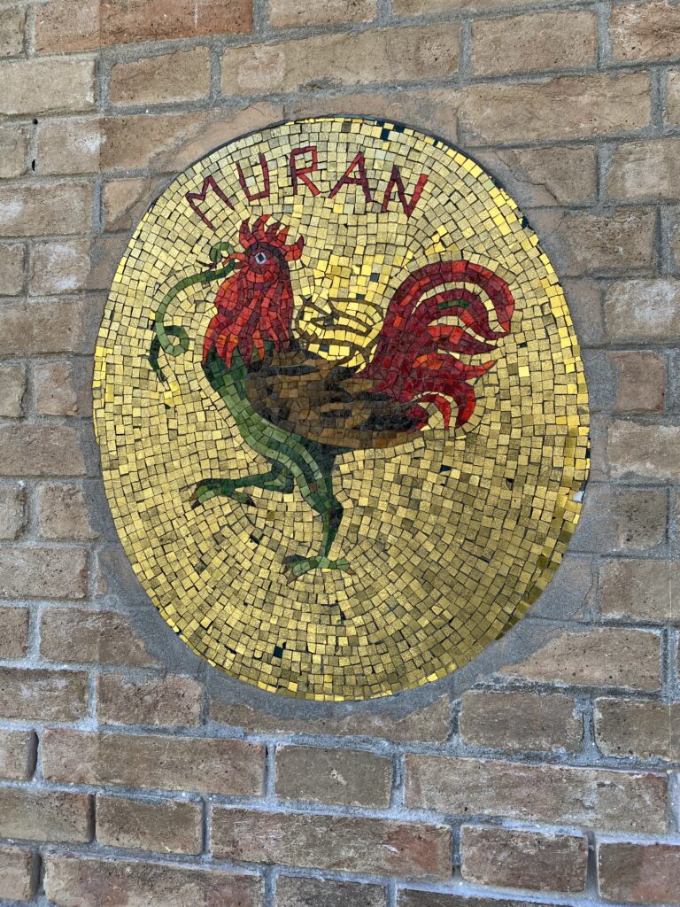 Mosaic of a rooster on a brick wall in Murano Italy