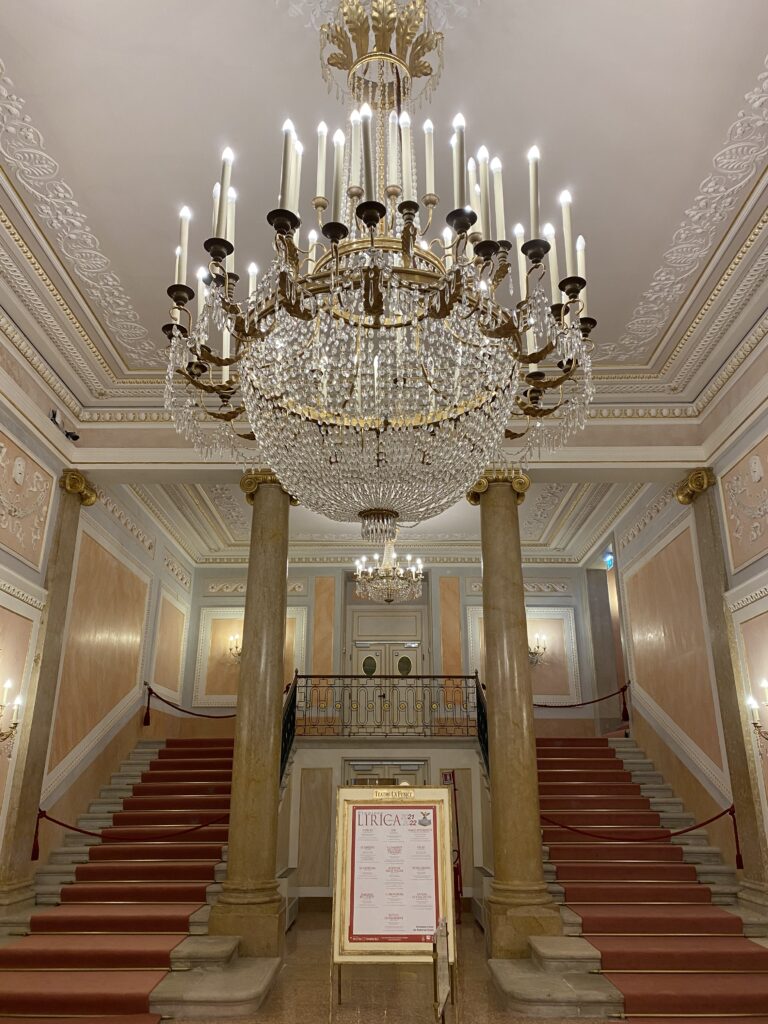 Foyer of historic Venetian opera house with pillars and large staircases