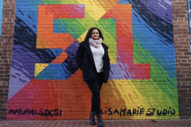 Woman standing in front of colorful Washington DC statehood mural