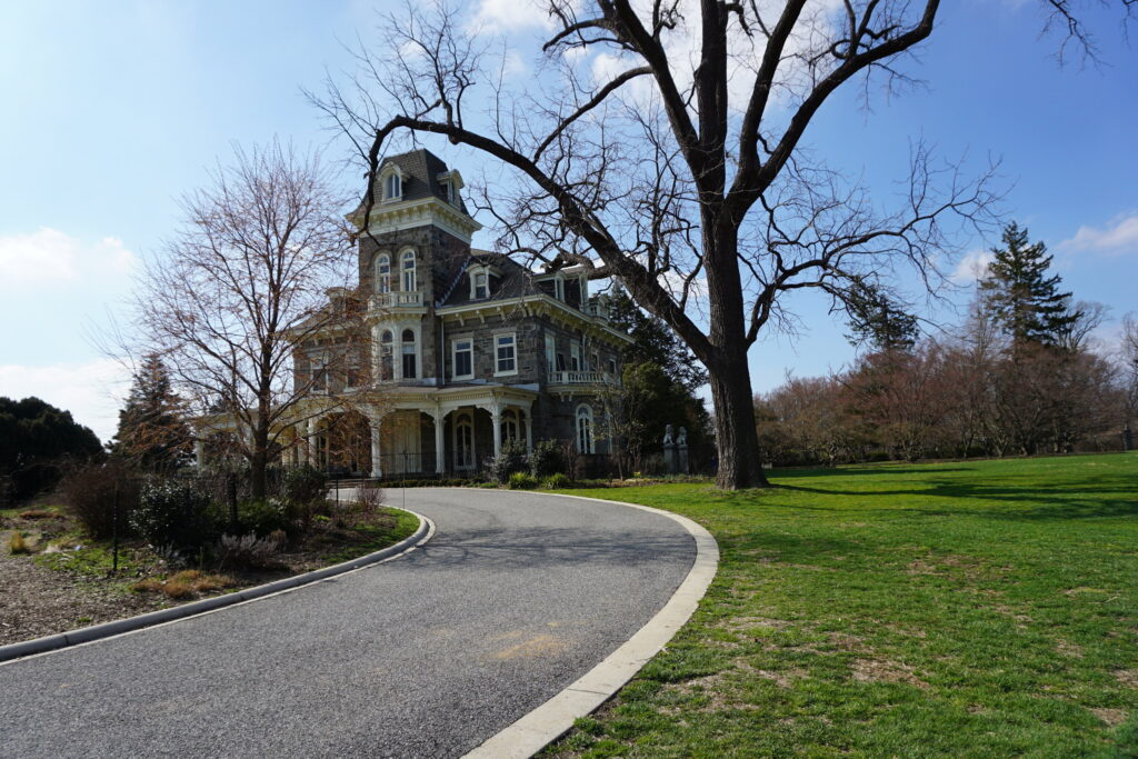 Historic mansion at the end of a long driveway along a green lawn