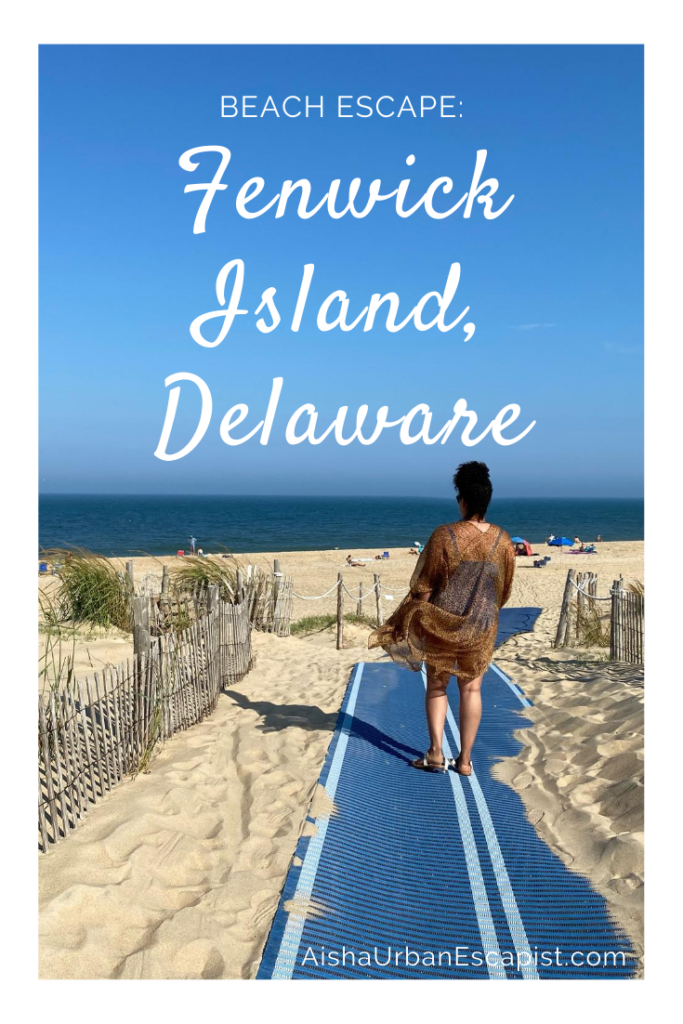 Woman walking on a path between sand dunes onto a beach in Fenwick Island Delaware