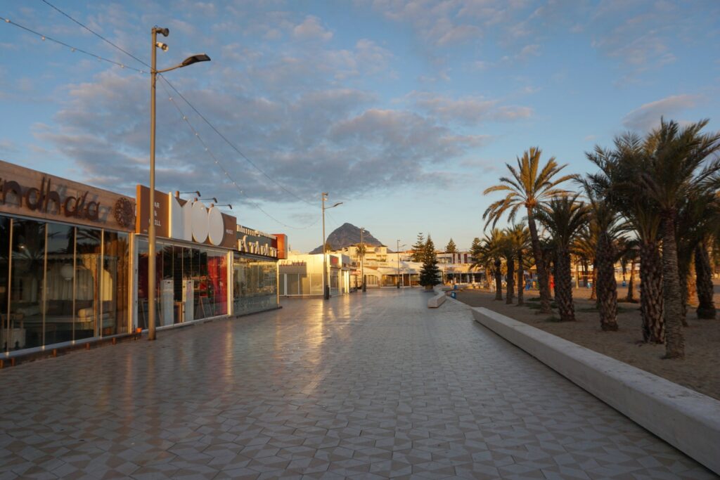 Boardwalk in Javea Spain lined with palm trees and bars and restaurants