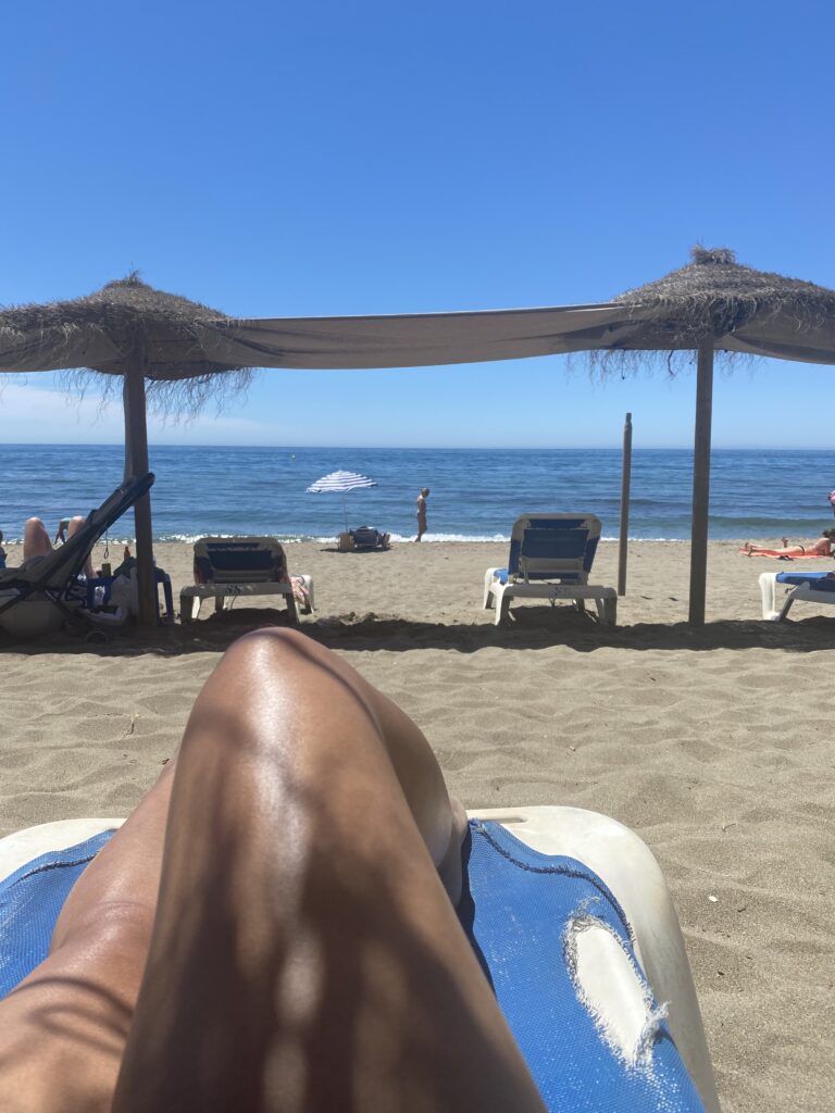 Woman's leg on a beach chair with a view of the ocean in Marbella Spain