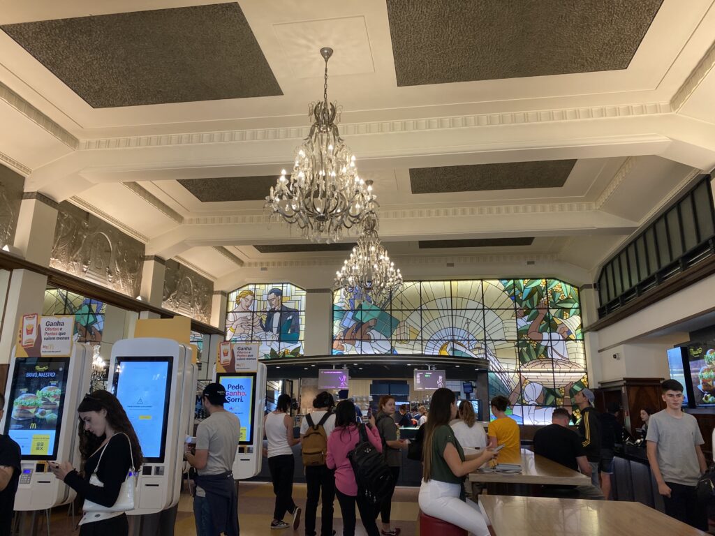 Interior of Imperial McDonald's in Portugal with art deco stained glass and chandeliers