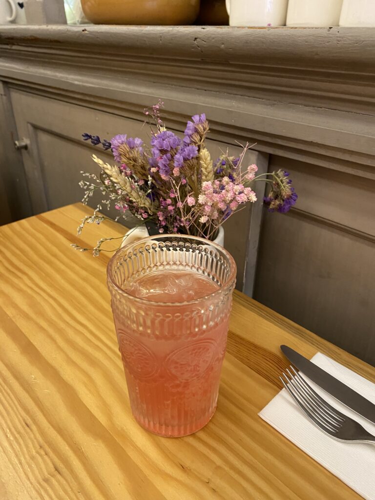 Pink drink and flowers on a table at a Portugal cafe