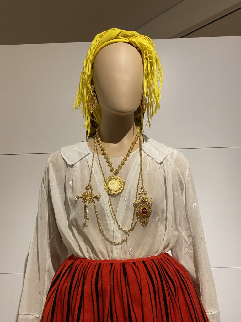 Museum mannequin wearing traditional northern Portuguese white blouse, red skirt, gold filigree jewelry, and yellow head scarf