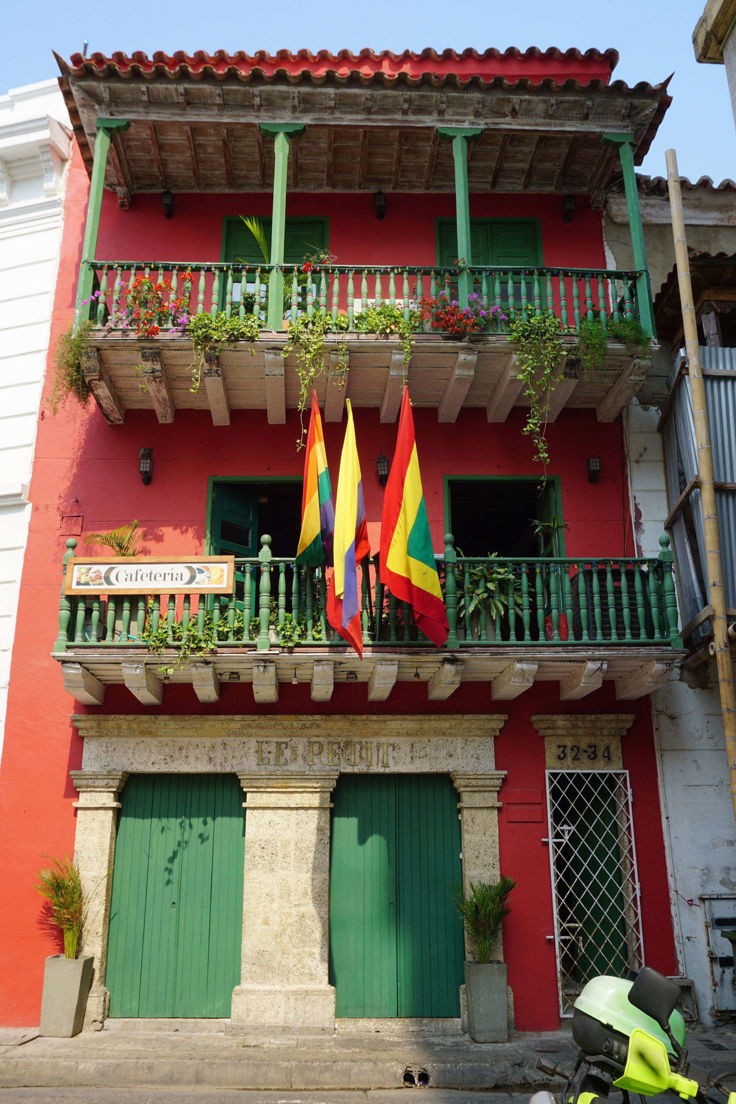 Colorful Spanish-style building with balconies and Colombian flags