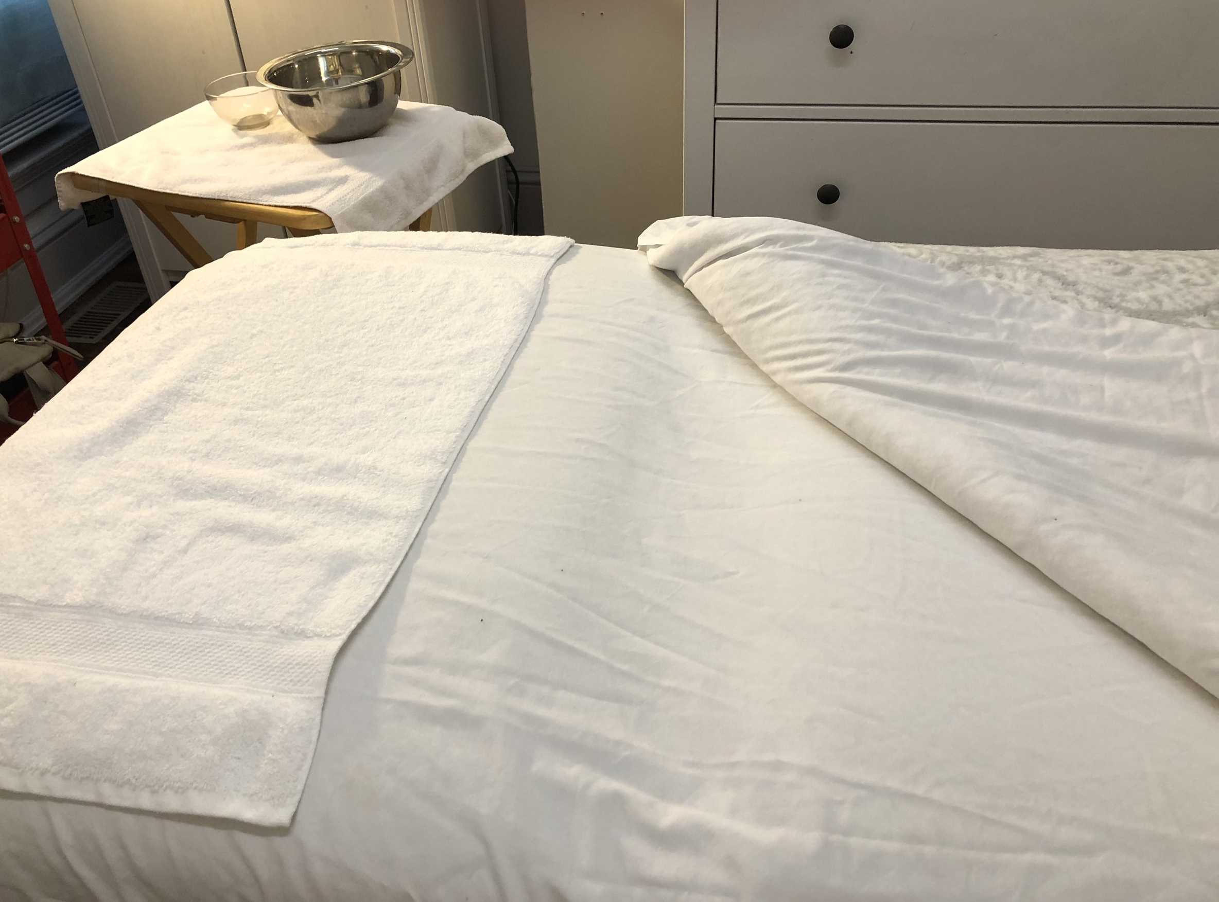 Massage table with white sheets in a spa room