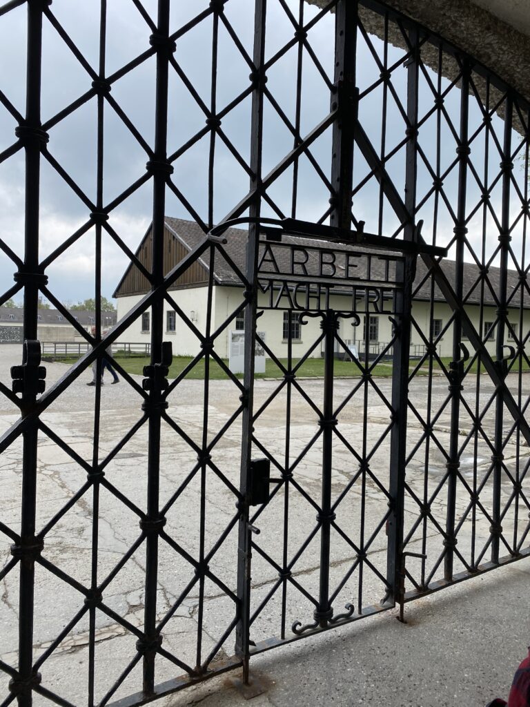 Iron fence at entrance to former concentration camp with the words "Arbeit Macht Frei"