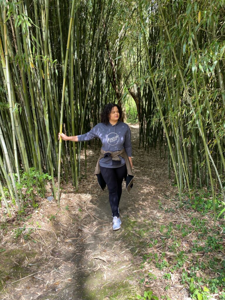Woman walking on a path with bamboo plants on both sides