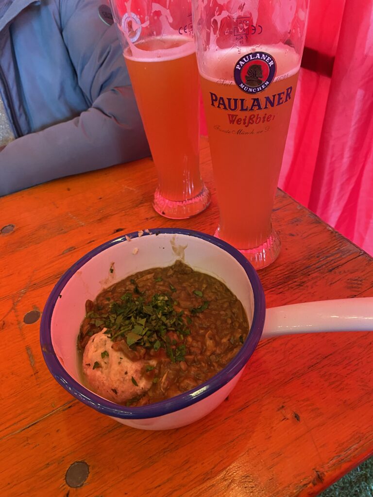 Bowl of Bavarian stew and two glasses of beer on a table