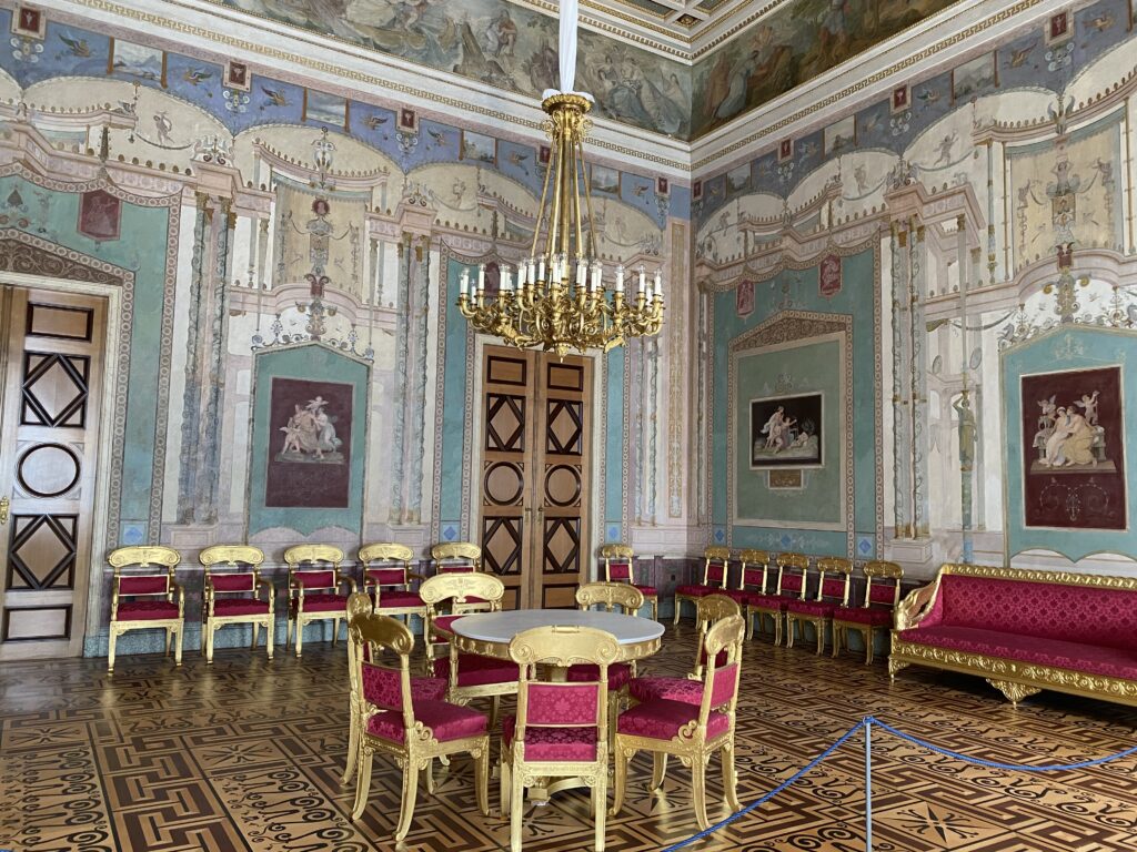 Ornate Munich palace room with a table and chairs in the center and benches against the walls