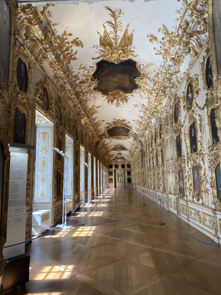 Palace hallway ornately decorated in gold on the walls and ceiling