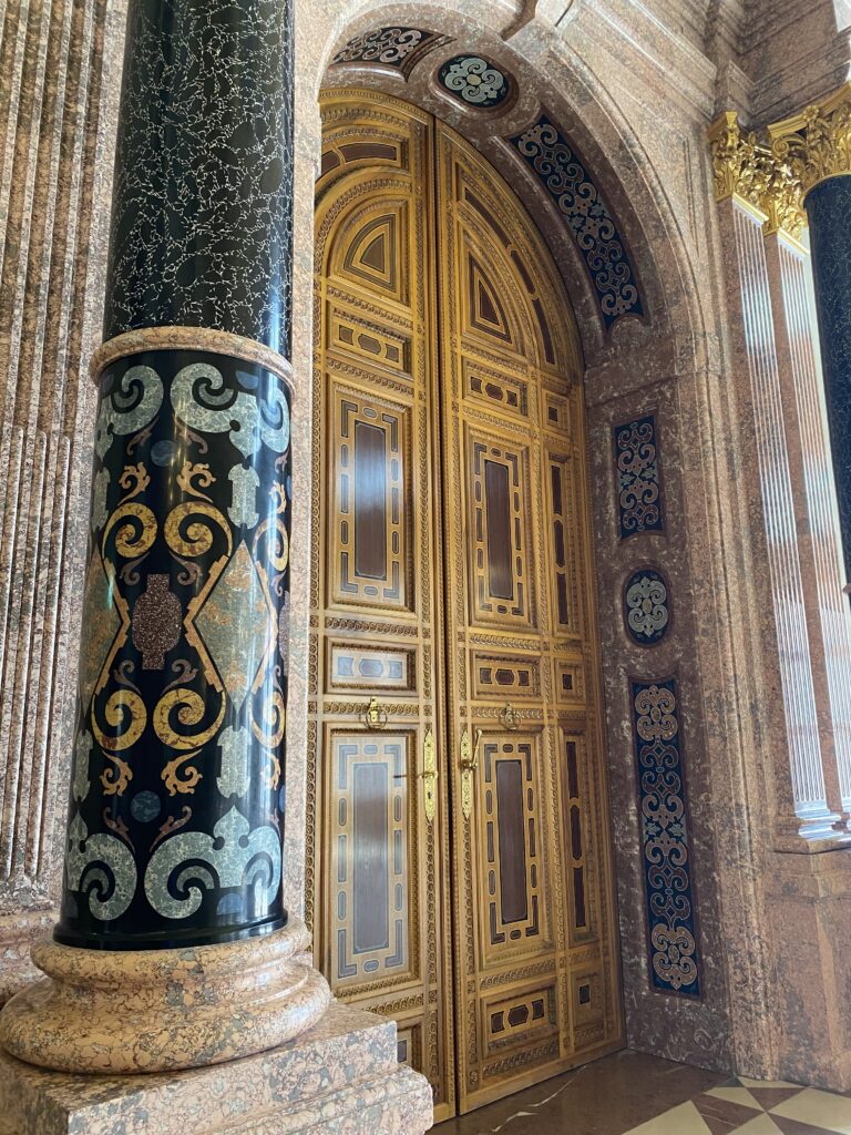 Munich palace double door with geometric design and two detailed pillars on each side