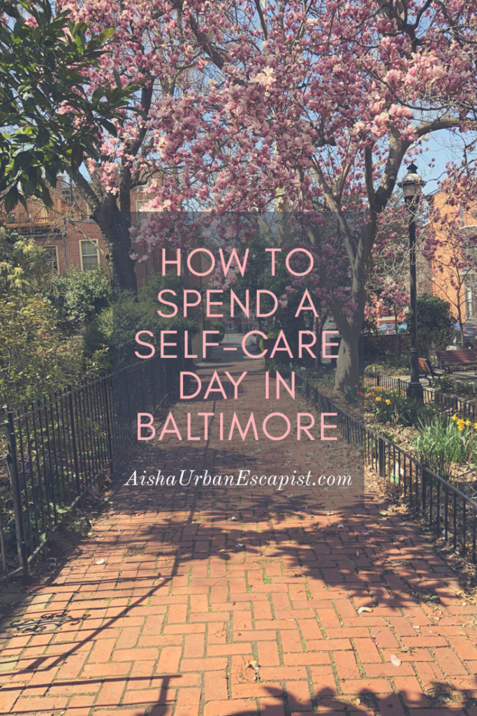 Brick sidewalk lined by magnolia trees with pink flowers and bushes and text saying how to spend a self-care day in Baltimore
