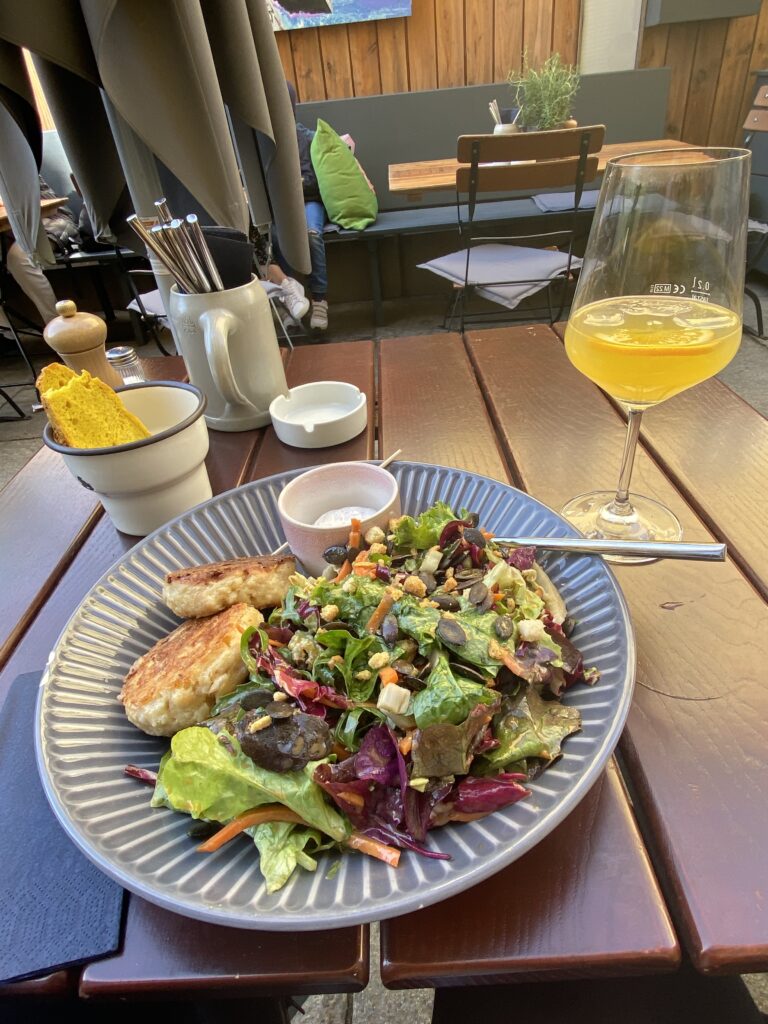 Plate of salad and a glass of juice on an outdoor restaurant table