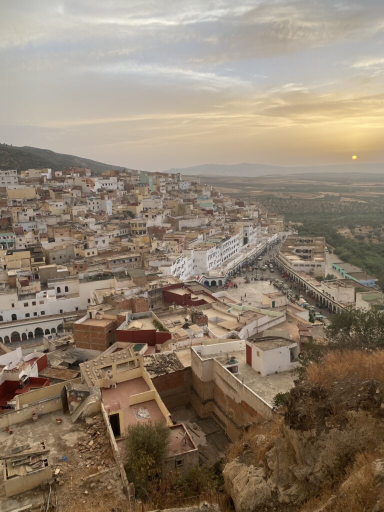 View of Morocco town on a hill with sun setting in distance
