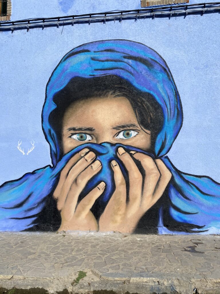 Mural of girl in blue headscarf on light blue wall